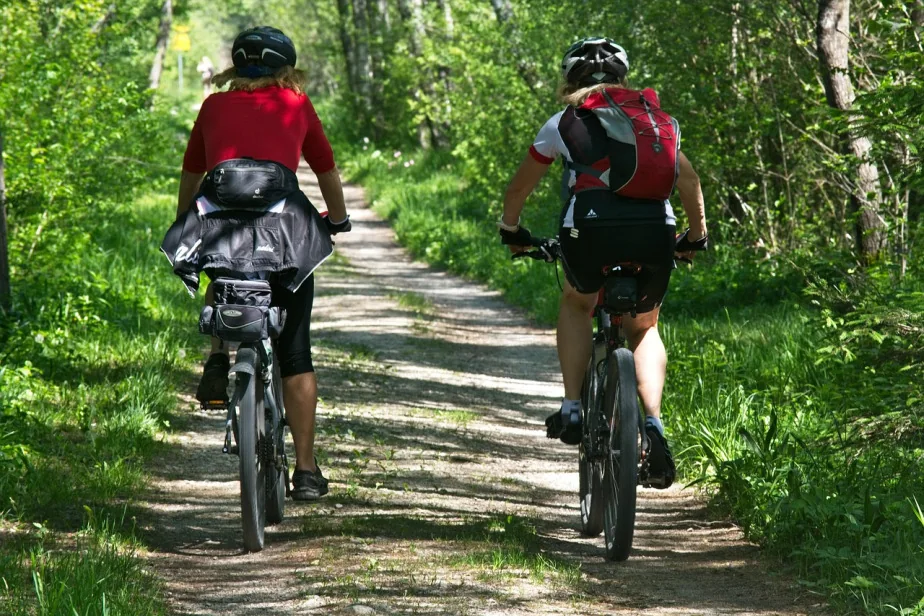 Due ciclisti in mountain bike su una strada sterrata nel bosco