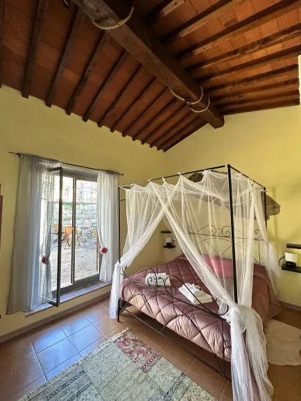 Madame room of the Tassinaia farmhouse, with a refined design and an intimate atmosphere, perfect for a luxury stay immersed in Tuscan nature.
