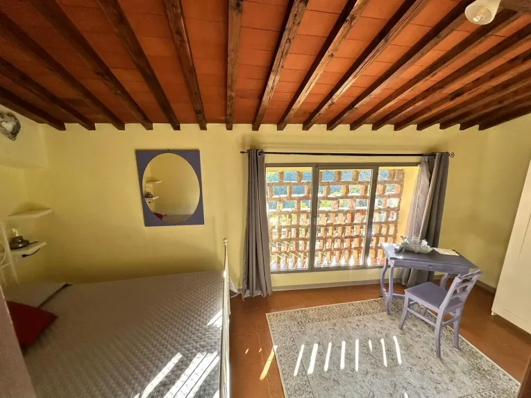 Violet room of the Tassinaia farmhouse, with elegant furnishings and a relaxing atmosphere, ideal for a peaceful stay in the Tuscan nature.