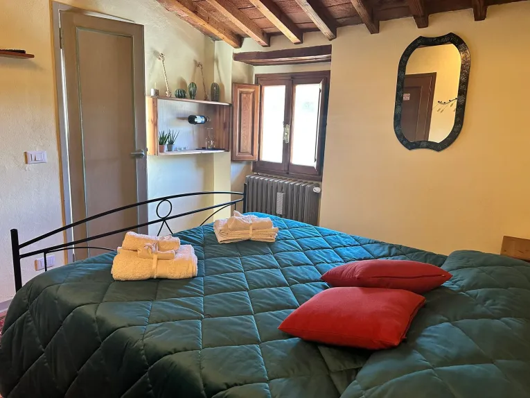 Enjoy room at the Tassinaia farmhouse, with welcoming furnishings and panoramic views of Tuscan nature.