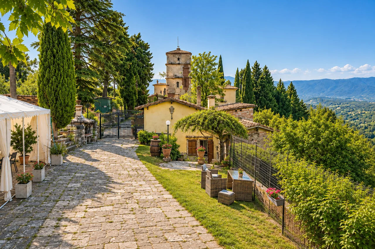 Il viale in pietra e la torretta medievale di Tassinaia sotto il sole toscano